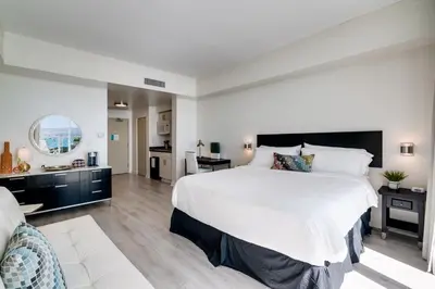 a bedroom with a large white bed and a bathroom at Ocean View Balcony steps from Restaurants, Peacock Park & Marina in Miami