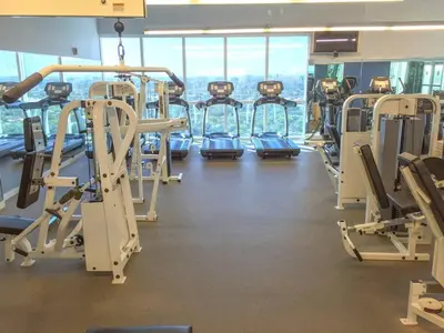 a gym with rows of treadmills and machines at City View Balcony steps from Restaurants, Peacock Park & Marina in Miami