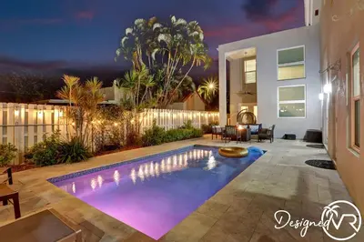 a swimming pool in the backyard of a house at night at Spacious 5BR home w heated pool fire pit in Hollywood
