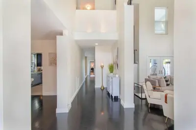a living room with white walls and a white staircase at Spacious 5BR home w heated pool fire pit in Hollywood