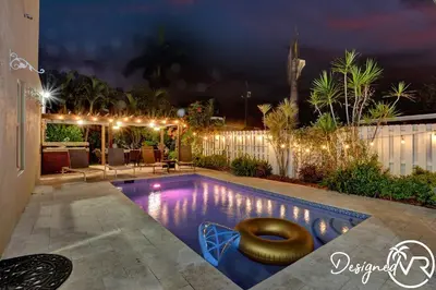 a swimming pool with a seat in a backyard at night at Spacious 5BR home w heated pool fire pit in Hollywood