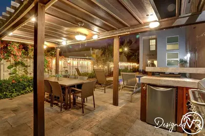 a patio with a table and chairs and a kitchen at Spacious 5BR home w heated pool fire pit in Hollywood