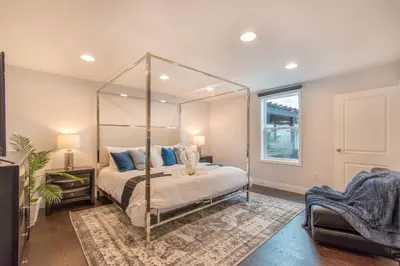 a bedroom with a canopy bed with blue pillows at Spacious 5BR home w heated pool fire pit in Hollywood