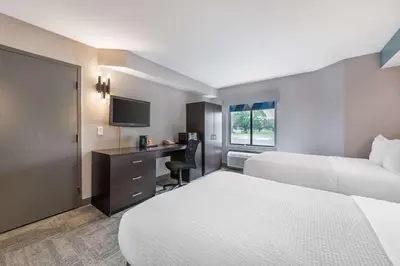 a hotel room with two beds and a desk at Sleep Inn Miami Airport in Miami