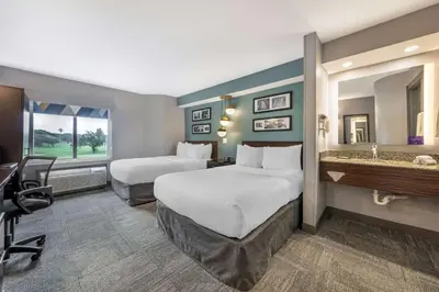 a hotel room with two beds and a desk at Sleep Inn Miami Airport in Miami