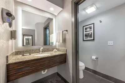 a bathroom with a sink and a toilet and a mirror at Sleep Inn Miami Airport in Miami