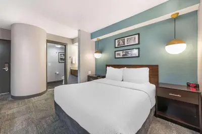 a bedroom with a large bed and a blue wall at Sleep Inn Miami Airport in Miami
