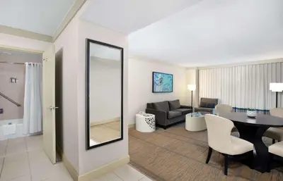 a living room with a table and a dining room at DoubleTree by Hilton Hotel Miami Airport & Convention Center in Miami