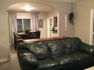 a black leather couch in a living room with a table at Modern 3/1 house close to Beaches and Midtown in Miami