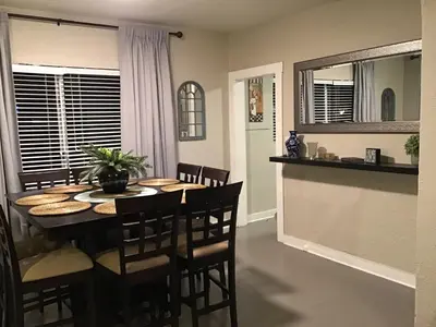 a dining room and kitchen with a table and chairs at Modern 3/1 house close to Beaches and Midtown in Miami