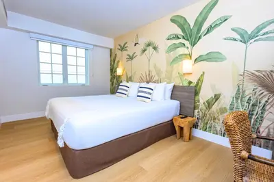 a bedroom with a large bed with plants on the wall at Casa Ocean in Miami Beach