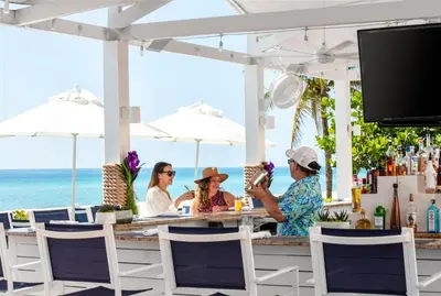 three women sitting at a bar at the beach at Trump International Beach Resort - Sunny Isles Beach in Miami Beach