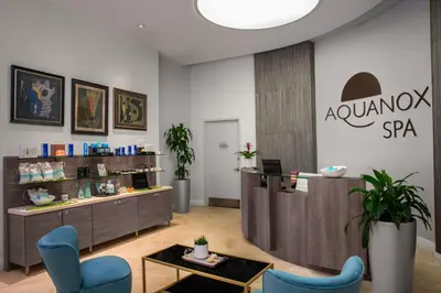 a salon with blue chairs and a table in a room at Trump International Beach Resort - Sunny Isles Beach in Miami Beach