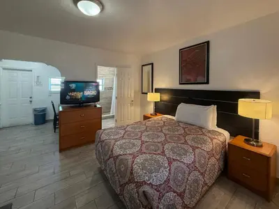 a hotel room with a bed and a television at Richard's Motel Extended Stay in Hallandale Beach