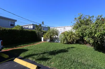 a yard with grass and palm trees and a building at Richard's Hotel in Hollywood