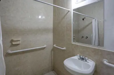 a bathroom with a sink and a shower with a mirror at Richard's Hotel in Hollywood