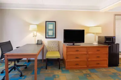 a room with a desk and a tv and a desk with a chair at La Quinta by Wyndham Ft. Lauderdale Plantation in Plantation