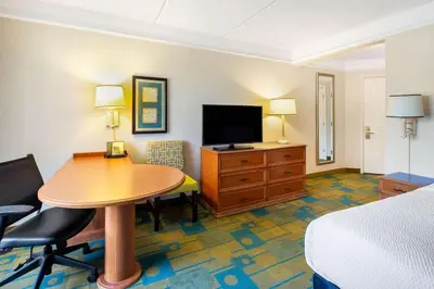 a hotel room with a table and a bed and a television at La Quinta by Wyndham Ft. Lauderdale Plantation in Plantation