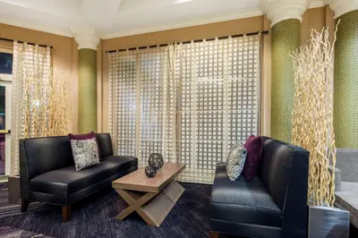 a living room with two chairs and a table at La Quinta by Wyndham Ft. Lauderdale Plantation in Plantation