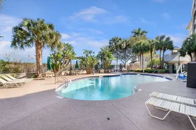 a swimming pool with a bench and palm trees at La Quinta by Wyndham Ft. Lauderdale Airport in Hollywood