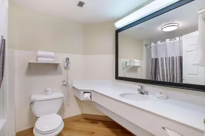 a bathroom with a sink and a toilet and a mirror at La Quinta by Wyndham Ft. Lauderdale Airport in Hollywood