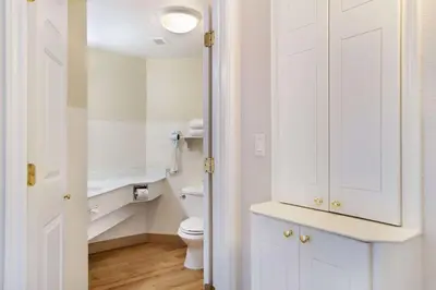 a bathroom with a toilet and a white cabinet at La Quinta by Wyndham Ft. Lauderdale Airport in Hollywood