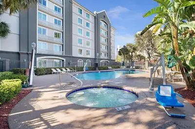 a swimming pool with a chair and a building at La Quinta by Wyndham Ft. Lauderdale Airport in Hollywood