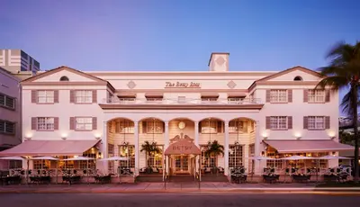 a large white building with tables in front of it at The Betsy Hotel, South Beach in Miami Beach