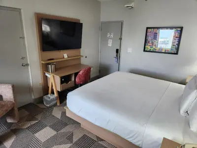 a bedroom with a bed and a desk and a television at Miami International Airport Hotel in Miami