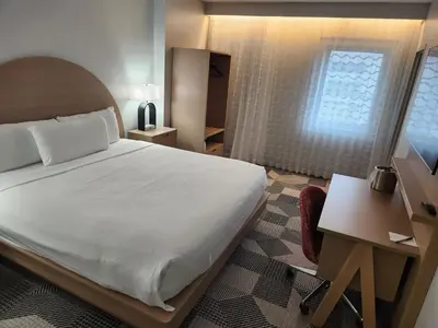 a bedroom with a bed and a desk and a window at Miami International Airport Hotel in Miami