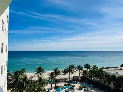 a view of the beach from the balcony of a resort at Miami Hallandale Condo, Partial Ocean View Direct Beach and Pool Access Miami Hollywood Beach in Hollywood