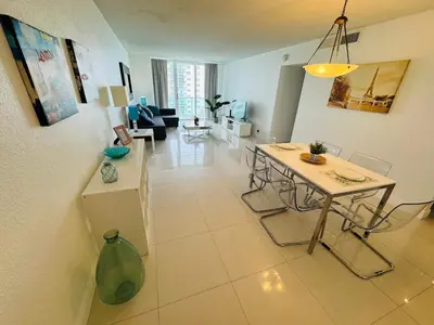 a living room with a table and a couch at Miami Hallandale Condo, Partial Ocean View Direct Beach and Pool Access Miami Hollywood Beach in Hollywood