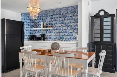 a kitchen with a table and chairs and a refrigerator at 1100 West South Beach Luxe Miami Condos by Joe Semary in Miami Beach