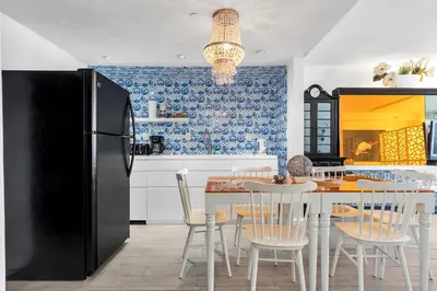 a kitchen with a black refrigerator and a table and chairs at 1100 West South Beach Luxe Miami Condos by Joe Semary in Miami Beach