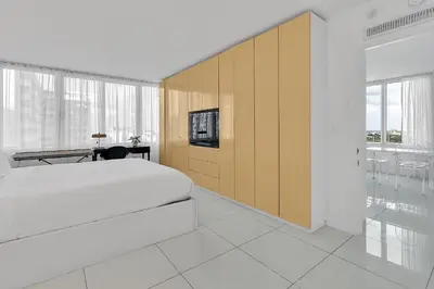 a bedroom with a bed and a desk and a tv at 1100 West South Beach Luxe Miami Condos by Joe Semary in Miami Beach