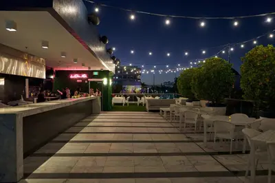a restaurant with lights and tables and chairs at night at Gale South Beach, Curio Collection By Hilton in Miami Beach