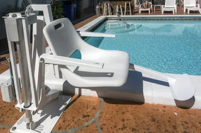a white reclining chair next to a swimming pool at Richard's Motel Courtyard in Hollywood
