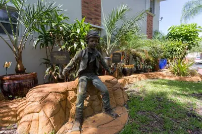 a statue of a boy sitting on a rock at Richard's Motel Studios in Hollywood