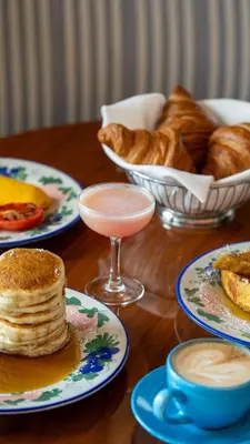 a table with plates of food and a bowl of bread at Mr. C Miami - Coconut Grove in Miami