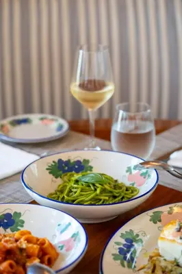 a wooden table with plates of food and a glass of wine at Mr. C Miami - Coconut Grove in Miami