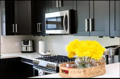 a kitchen with a microwave and a vase of yellow flowers at Pool House 3B-2B King Bed - BBQ - EV in Hollywood