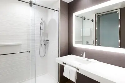 a bathroom with a sink and a shower and a mirror at AC Hotel by Marriott Miami Airport West/Doral in Miami