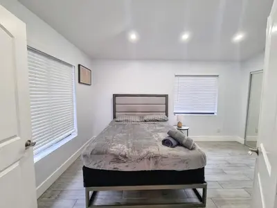 a bedroom with a bed and two windows at Downtown Hollywood - 3 miles to Beach - Sleeps 8 in Hollywood