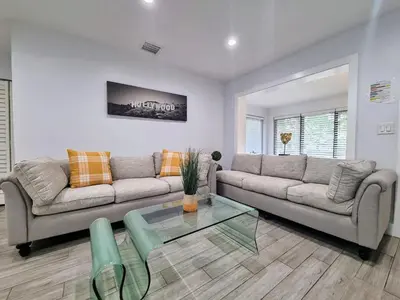 a living room with two couches and a glass table at Downtown Hollywood - 3 miles to Beach - Sleeps 8 in Hollywood