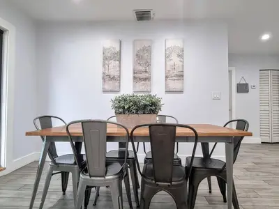 a dining room table with chairs and a potted plant at Downtown Hollywood - 3 miles to Beach - Sleeps 8 in Hollywood