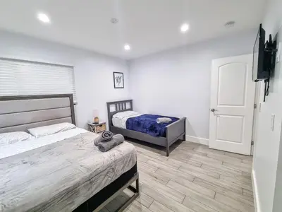 a bedroom with two beds and a flat screen tv at Downtown Hollywood - 3 miles to Beach - Sleeps 8 in Hollywood