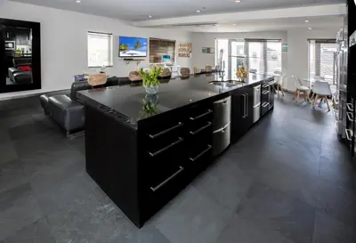 a kitchen with a black island in a living room at Posh South Beach in Miami Beach