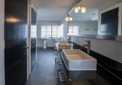 a bathroom with a row of sinks and a mirror at Posh South Beach in Miami Beach