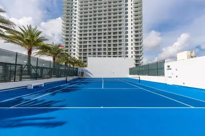 a tennis court in front of a tall building at Private Ocean Condos at Hyde Beach Resort & Residences in Hollywood