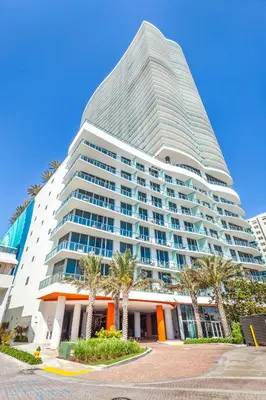 a tall building with palm trees in front of it at Private Ocean Condos at Hyde Beach Resort & Residences in Hollywood